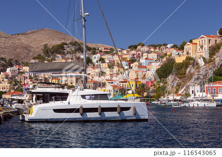 Bright multi-colored facades of houses on the shore of the bay in the village Symi 116543065