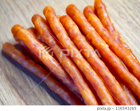 Brightly lit sausages on a wooden surface, likely to entice meat enthusiasts. 116543265