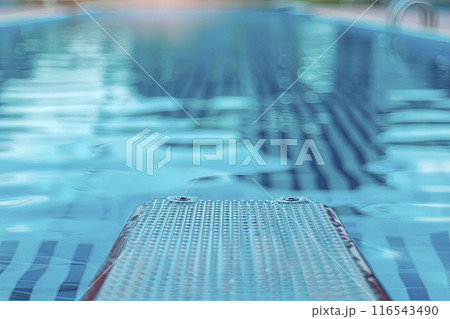 closeup of divingboard and swimming pool background defocused closeup of divingboard and swimming pool background defocused 116543490