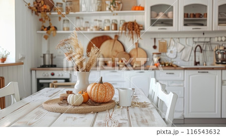 a cozy kitchen decorated for autumn, featuring pumpkins, dried flowers, and warm, rustic elements  116543632