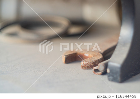Locksmith tools such as a wrench and an adjustable wrench with selective focus lie on a beige surface and gather dust idle. 116544459