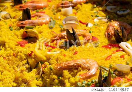 Seafood paella, Spanish rice dish with shrimp, mussels, clams, yellow rice in large pan close up 116544927