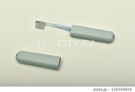 A toothbrush case and a toothbrush on a green background. 116544959