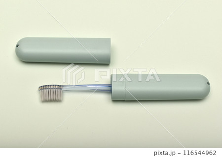 A toothbrush case and a toothbrush on a green background. A toothbrush case and a toothbrush on a green background. 116544962