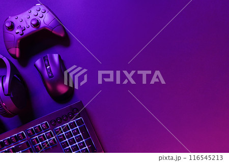 Gaming gadgets on illuminated purple desk 116545213