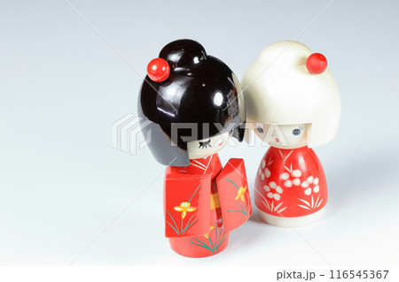 Japanese wooden dolls "kokeshi" in red Kimono suit, toy for a decoration, souvenir from Japan Isolated on white background. Japanese wooden dolls "kokeshi" in red Kimono suit, toy for a decoration, souvenir from Japan Isolated on white background. 116545367