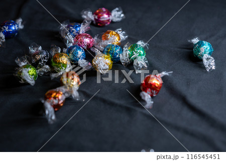 Vienna, Austria August 20, 2022. Beautiful image with a group of Lindt Lindor chocolates, of different shapes, in multicolored wrappers. Concept of relaxation, pampering. Selective focus. 116545451