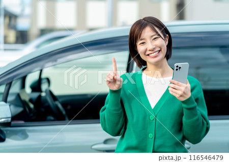 車の前でスマートフォンを持った笑顔の女性 スマホと車 車の前でスマートフォンを持った笑顔の女性 スマホと車 116546479