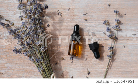 Dried lavender flowers with glass dropper of natural essential oil. Organic herbal aromatherapy healthy glass bottle. Home fragrance extract Dried lavender flowers with glass dropper of natural essential oil. Organic herbal aromatherapy healthy glass bottle. Home fragrance extract 116547951