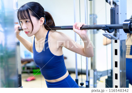 ジムで体を鍛える女性　バーベルスクワット　筋トレ女子　ワークアウト　ヒップアップ　トリミングアップ 116548342