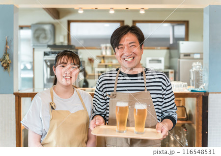 グラスの生ビールを持つ居酒屋・飲食店・カフェスタッフ 116548531