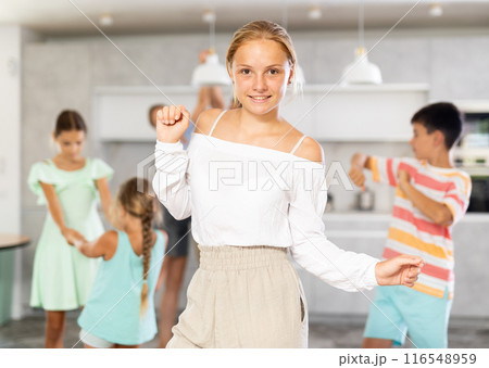 Behind cheerful girl, big family of parents, sisters, brother is rejoicing, dancing, having fun. 116548959