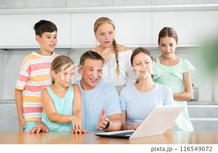 Large family uses a laptop to communicate with friends and relatives via Internet Large family uses a laptop to communicate with friends and relatives via Internet 116549072