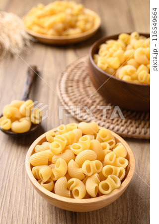 Raw macaroni pasta in bowl on wooden background, Food ingredient Raw macaroni pasta in bowl on wooden background, Food ingredient 116549664