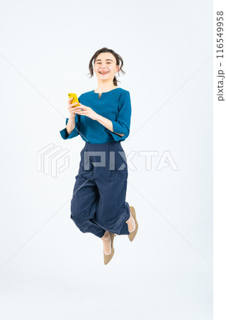 スマホを見ながらジャンプする白人女性の全身写真 スマホを見ながらジャンプする白人女性の全身写真 116549958