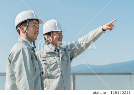 青空の中に立つ作業服を着た作業員（建設・建築・設計・不動産・土木・工事・現場監督・運送） 116550211