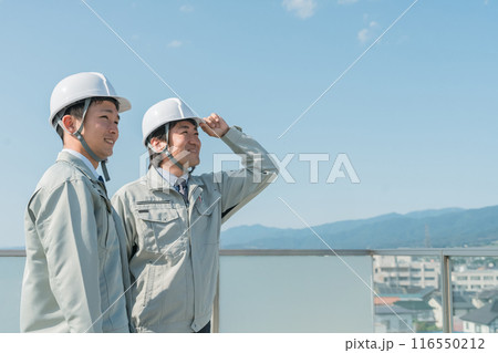 青空の中に立つ作業服を着た作業員（建設・建築・設計・不動産・土木・工事・現場監督・運送） 116550212