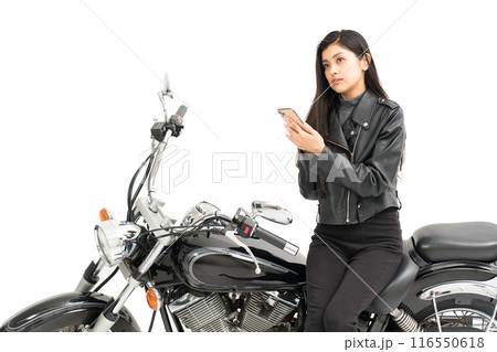 バイクに座ってスマホの地図を見て悩む若い女性 バイクに座ってスマホの地図を見て悩む若い女性 116550618