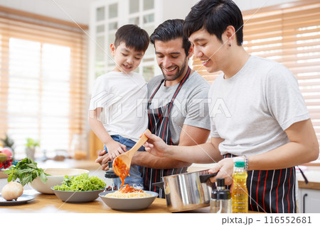Happy cheerful LGBTQ couple cooking a food together in kitchen, a LGBT couple with adopted child cooking a food. Diversity lifestyles concept. 116552681