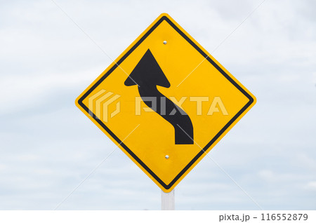 Left curve warning sign is on sky background. Left curve warning sign is on sky background. 116552879
