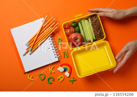 Yellow lunch box with delicious food and school supplies Yellow lunch box with delicious food and school supplies 116554206