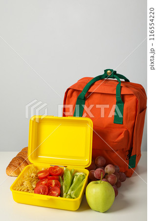 Lunch boxes with food and a school backpack 116554220