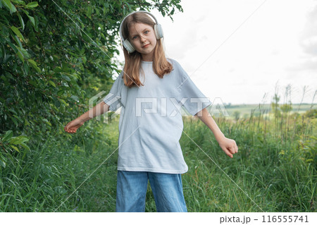 A child  with headphones listening to music and dancing. 116555741