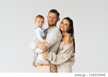 Portrait of a happy young family with a one-year-old son in their arms with copy space 116555946