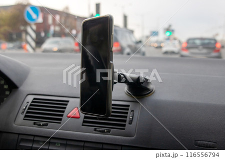 A cell phone is placed on the dashboard inside a car A cell phone is placed on the dashboard inside a car 116556794
