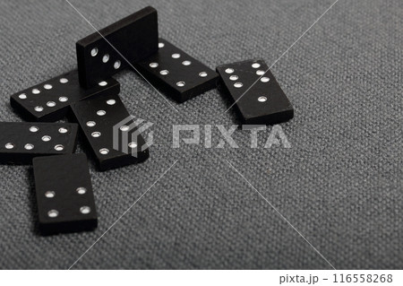 Domino knuckles on a surface covered with a coarse gray cloth. 116558268