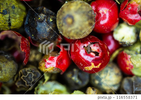 Close-up macro a vibrant mix of green, red, and black peppercorns. 116558371