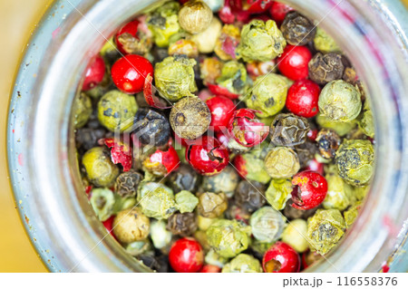 Vibrant mix of red, green, and black peppercorns inside a jar. 116558376