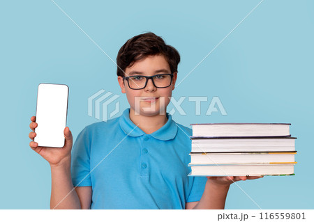 A handsome boy, wearing glasses , holding a stack of books and smartphone with white screen 116559801