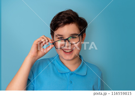 A funny happy handsome boy, dark-haired, wearing lopsided glasses and a blue T-shirt, 116559815