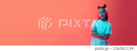 Portrait of young girl in white t-shirt in stylish hairstyle smiling against pink background in neon light 116561134