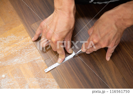 中古住宅のリフォームで廊下の床にフロアタイルを貼るクロス職人 116561750