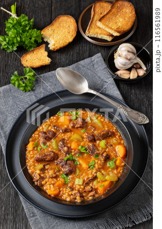 beef barley soup in a bowl, top view 116561989