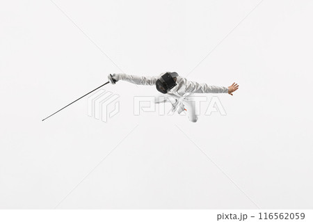 Young man, fencer in full gear lunges forward, poised to strike with their epee against white studio background. Movement. Young man, fencer in full gear lunges forward, poised to strike with their epee against white studio background. Movement. 116562059