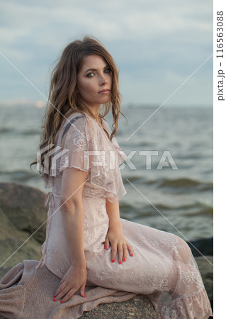 Cute young adult female model with windy brown hair walking outdoor Cute young adult female model with windy brown hair walking outdoor 116563088