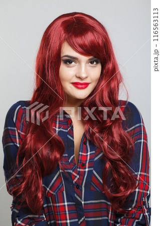 Beautiful young woman with a bright makeup and a smooth long curly hair. Model 116563113