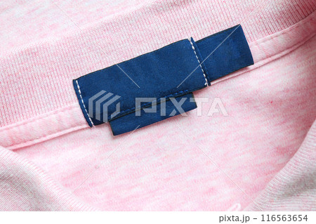 Blank blue laundry care clothes label on pink shirt fabric texture background Blank blue laundry care clothes label on pink shirt fabric texture background 116563654