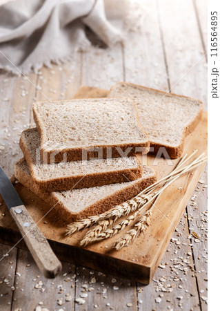 Healthy wholemeal bread slices on rustic wooden table.  116564895