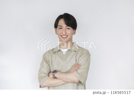 腕組みをしたカメラ目線で笑顔の若い男性 116565517