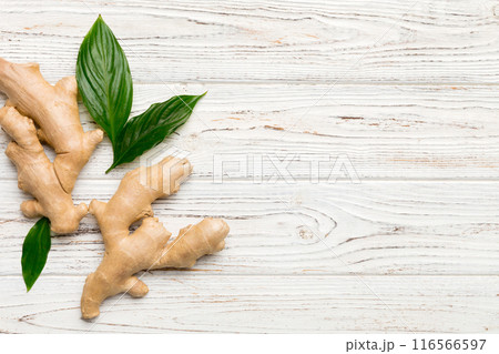 Finely dry Ginger powder in bowl with green leaves isolated on colored background. top view flat lay Finely dry Ginger powder in bowl with green leaves isolated on colored background. top view flat lay 116566597