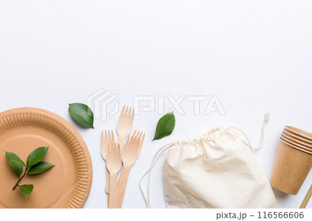 set of empty reusable disposable eco-friendly plates, cups, utensils on light white colored table background. top view. Biodegradable craft dishes. Recycling concept. Close-up set of empty reusable disposable eco-friendly plates, cups, utensils on light white colored table background. top view. Biodegradable craft dishes. Recycling concept. Close-up 116566606