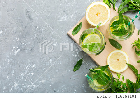 Caipirinha, Mojito cocktail, vodka or soda drink with lime, mint and straw on table background. Refreshing beverage with mint and lime in glass top view flat lay 116568101
