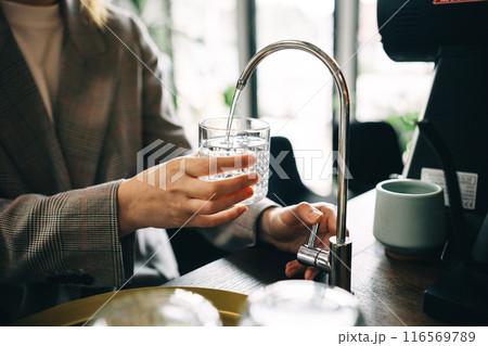 Person Filling Glass With Filtered Water at a Cafe Person Filling Glass With Filtered Water at a Cafe 116569789