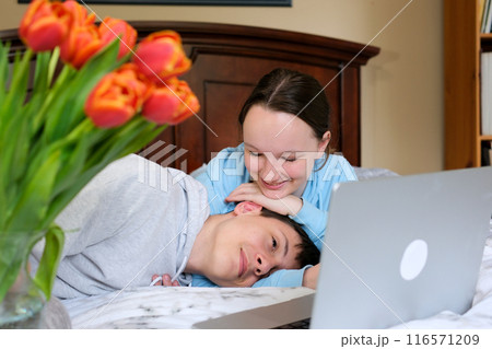 Caucasian couple young man and woman fall asleep watching tv while sitting on leather sofa in apartment. Sleepy male female watching TV at home at night after holiday party. Dolly shot 116571209