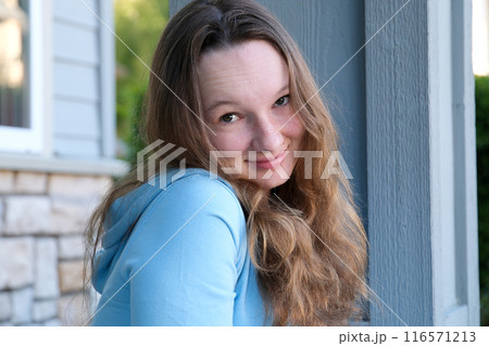 Young girl student smiling near university. Cute girl student holds books. Learning, education concept 116571213