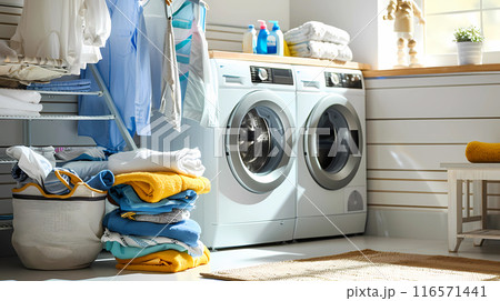 Laundry piled up near white washing machines in a modern laundry room Laundry piled up near white washing machines in a modern laundry room 116571441